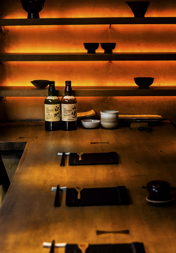 飲食店の店内写真。都内の和食屋の店内。木のカウンターと漆の食器が並ぶディスプレイ。
