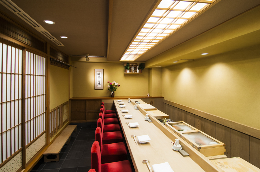 飲食店の店内写真。白木のカウンターだけの落ち着いた寿司屋