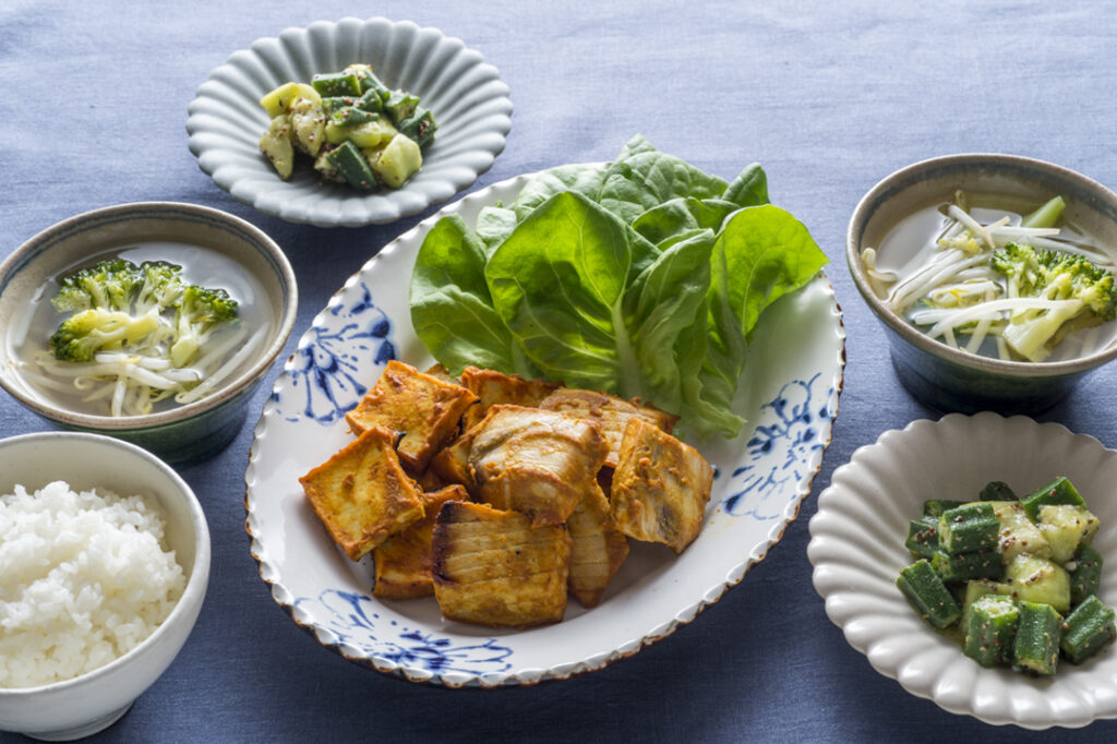 複数皿の写真。豆腐の味噌焼き、オクラの胡麻和え、その他の皿。